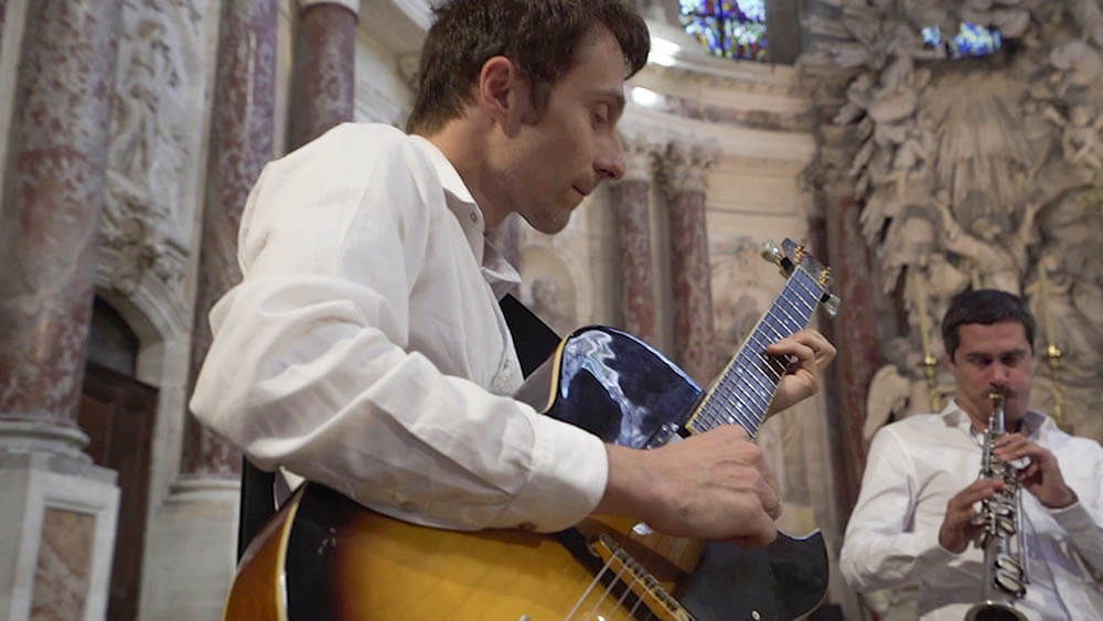 Jazz guitar and saxophone duo performing during a church wedding ceremony in France