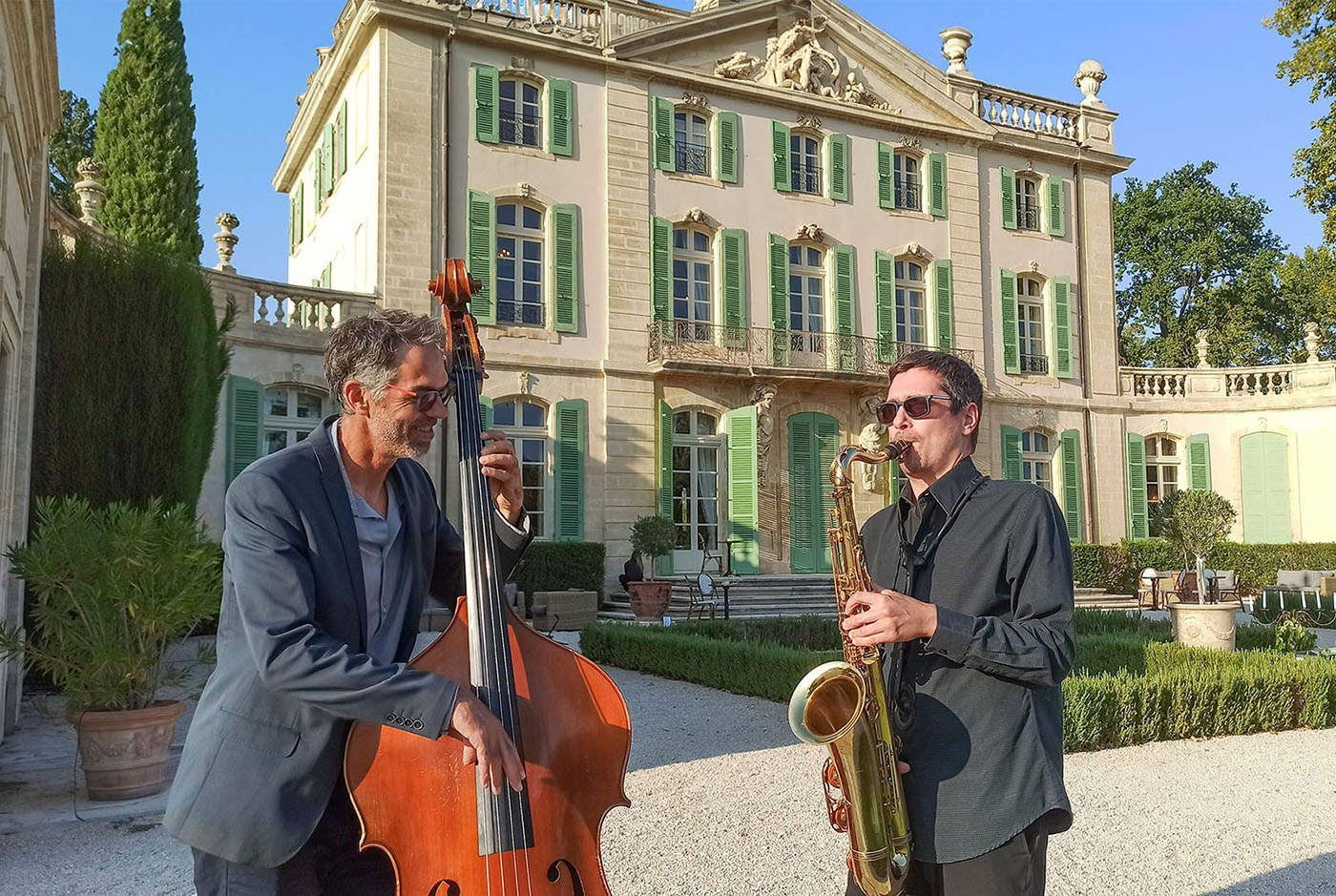 Jazz trio with saxophone, guitar and double bass in front of a château on the French Riviera