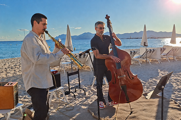 Saxophone and double bass duo performing by the sea at a wedding venue in Cannes