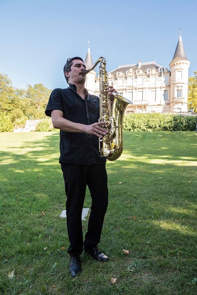 Saxophonist performing in front of a château wedding venue in Provence
